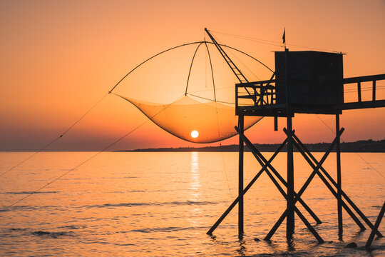 Paysage de Loire atlantique: une p&ecirc;cherie de bord de mer avec le soleil couchant et le soleil est pris dans les filets de p&ecirc;che