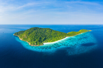 Aerial view of a beautiful tropical island surrounded by coral reef and a clear ocean