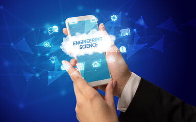 Female hand holding smartphone with ENGINEERING SCIENCE inscription, cloud technology concept