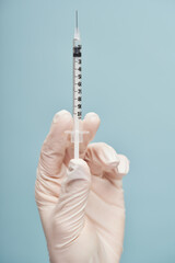 Doctor holding a syringe for injection in studio