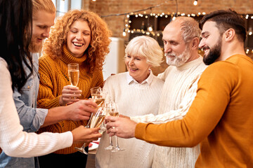People holding glass of champagne celebrating winter holidays