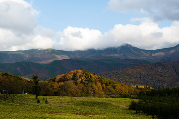秋の知床　雲がかかった紅葉の知床連山と開拓地跡（北海道・斜里町）