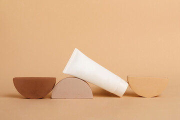 Cosmetic tube lies on the geometrical podiums.Blank box with copy space,mockup.Beautiful earth colors.Concept of the natural cosmetic for women.Good for placing your product.