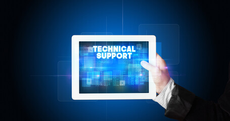 Young business person working on tablet and shows the inscription: TECHNICAL SUPPORT
