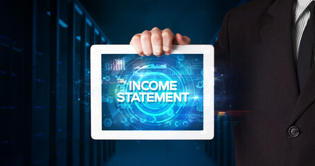 Young business person working on tablet and shows the inscription: INCOME STATEMENT, business concept
