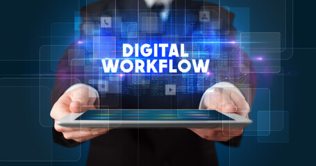 Young business person working on tablet and shows the inscription: DIGITAL WORKFLOW