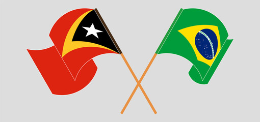 Crossed and waving flags of East Timor and Brazil