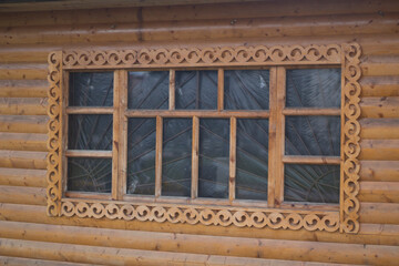 Wooden window with platband. Patterned platband made of wood