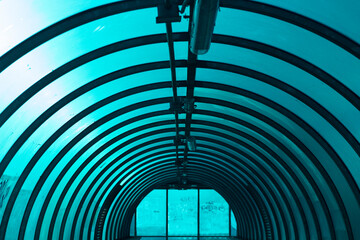 An arched tunnel across the road. Inside the overhead passage above the track