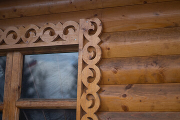 Wooden window with platband. Patterned platband made of wood