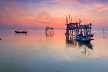 Beautiful view on sunrise with wooden boat as a subject at Kenjeran beach,Surabaya.Indonesia