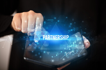 Businessman holding a foldable smartphone with PARTNERSHIP inscription, business concept