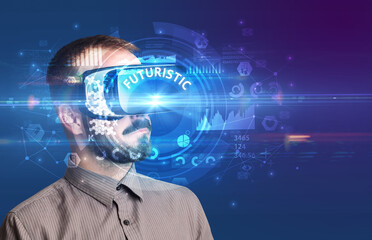 Businessman looking through Virtual Reality glasses with FUTURISTIC inscription, innovative technology concept