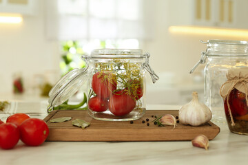 Tomatoes and dill in pickling jar on kitchen table