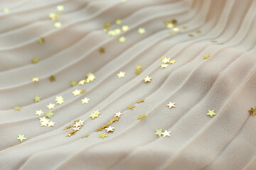 Confetti stars on beige fabric. Christmas celebration