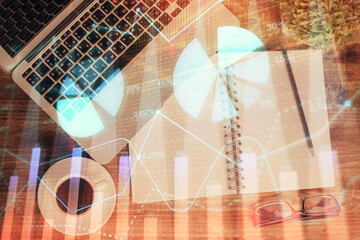 Financial market graph and top view computer on the desktop background. Double exposure. Investment concept.