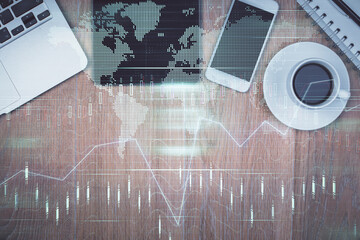 Multi exposure of forex graph hologram over desktop with phone. Top view. Mobile trade platform...