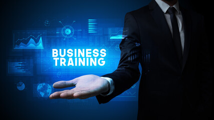 Obraz premium Hand of Businessman holding BUSINESS TRAINING inscription, business success concept