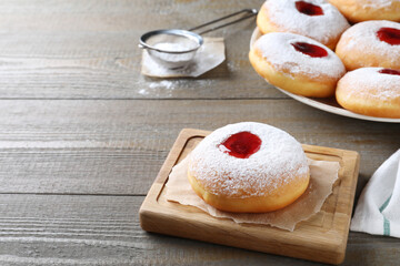 Hanukkah doughnut with jelly and sugar powder served on wooden table