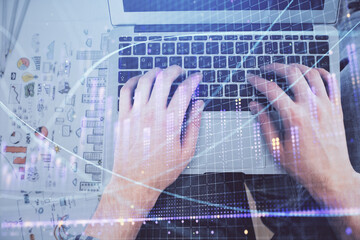 Obraz na płótnie Canvas Double exposure of man's hands typing over laptop keyboard and forex chart hologram drawing. Top view. Financial markets concept.