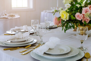 Tables set and flowers for a wedding reception.