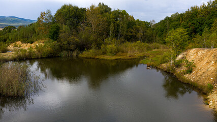 Fototapeta na wymiar A little lake between trees in russian countryside