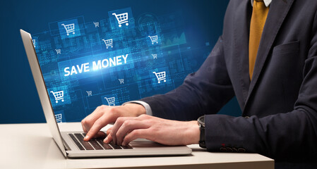 Businessman working on laptop with SAVE MONEY inscription, online shopping concept