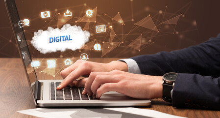 Businessman working on laptop with DIGITAL inscription, modern technology concept