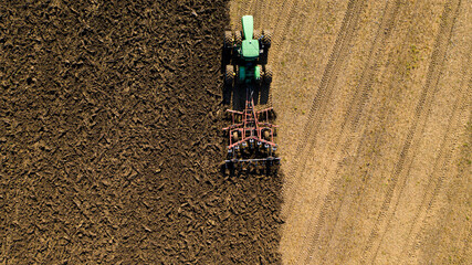 Tractor plows the field photographed by drone