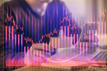 Double exposure of man's hands holding and using a phone and financial graph drawing. Analysis concept.