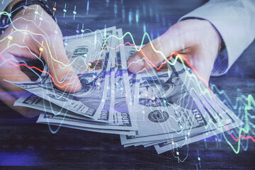Multi exposure of financial graph drawing hologram and USA dollars bills and man hands. Analysis concept.
