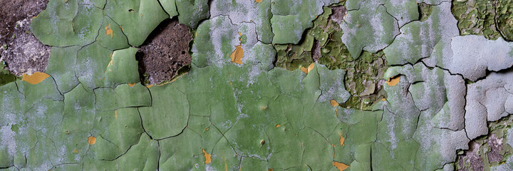 Peeling paint on the wall. Panorama of a concrete wall with old cracked flaking paint. Weathered...