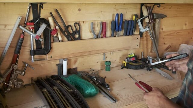 Joiner woodworker choosing construction carpentry tools in his workshop. DIY concept.