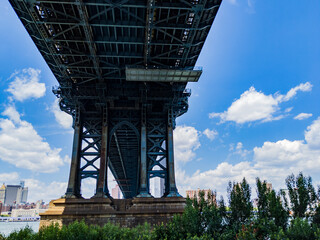 Underside of Brooklyn Bridge on cloudy summer day