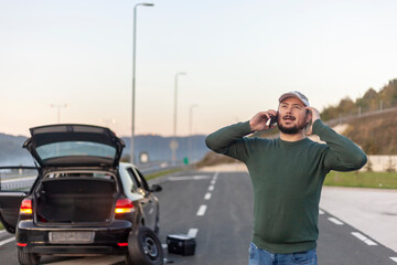 Naklejka premium Man talking on cell phone, highway problem with car