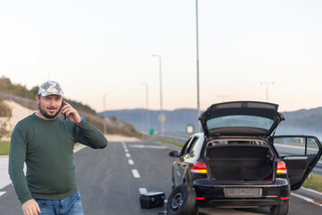 Man talking on cell phone, highway problem with car