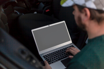 Roadside assistance.-An electrician is trying to detect a car malfunction