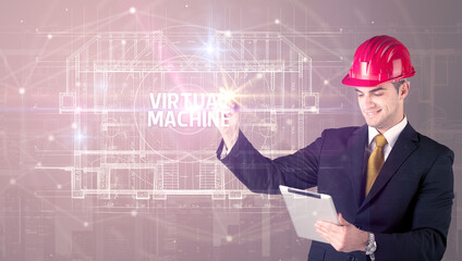 Handsome architect with helmet drawing VIRTUAL MACHINE inscription, new technology concept