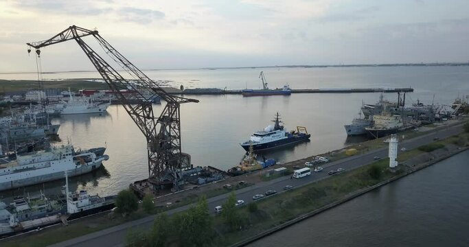 4K aerial early evening video of Lomonosov (Oranienbaum) harbour and port shipyard service area, Finnish Bay panorama, boats moored at Baltic Sea coast, in surroundings of Russia's northern capital
