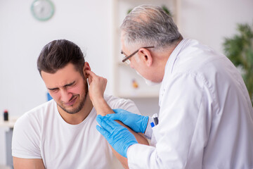 Obraz premium Young man visiting experienced doctor otolaryngologist