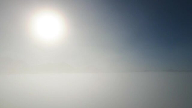 Distant mountain range and thin layer of fog on the valleys. Drone shot