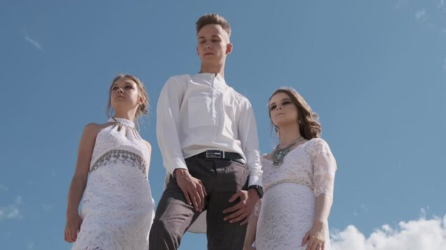 A love triangle, a man posing with two young girls in white dresses, friendship, the concept of polygamy.