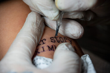 Realizando tatuaje en brazo femenino