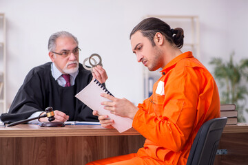 Old male judge meeting with young captive in courthouse