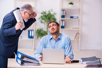 Obraz premium Old boss and his young assistant in the office