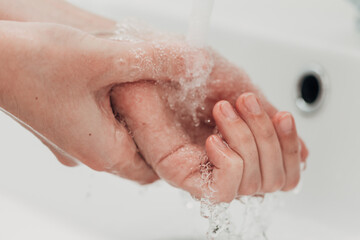 Fototapeta premium The Girl Washes Her Hands to Avoid Infection With the Virus COVID-19