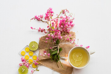 Fototapeta na wymiar pink flower on sack with healthy drinks honey lemon for health care relax arrangement flat lay style on background white 