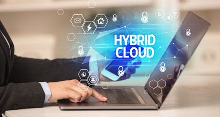 HYBRID CLOUD inscription on laptop, internet security and data protection concept, blockchain and cybersecurity