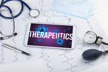 Tablet pc and doctor tools on white surface with THERAPEUTICS inscription, pandemic concept