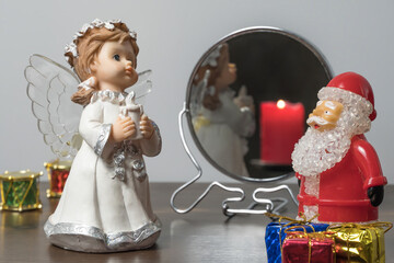 Christmas or new year's eve. Angel and Santa Claus with gifts at night on the background of a lit candle. New year holiday.